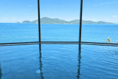 【悠久の湯／オーシャンビュー展望大浴場】長門五名湯に数えられる美肌の湯。そのやわらかな湯面の先に広がるのは、青海島と深川湾の穏やかな海景。ここでしか味わえない、静かな安らぎが満ちていく。