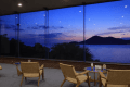 【海の見える展望ラウンジ】夕暮れの光が差し込むラウンジでは、海景が一日の終わりを静かに告げます。心を休めるための、上質なひとときがここにあります。