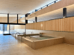 [AQUAIGNIS GARDEN SPA / Indoor Bath] The indoor bath at "AQUAIGNIS GARDEN SPA" is available to hotel guests. As you soak in the tranquil water surrounded by wooden louvers and light-colored stone, the tension in your body will slowly melt away along with the air of Karuizawa.