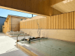 【AQUAIGNIS GARDEN SPA / Open-Air Area】 An open-air area spreads out under the Karuizawa sky. The blue sky and greenery reflected on the water's surface quietly convey that this is a special place. Take some time to reconnect with yourself during your journey, moving between the hot springs and the fresh air.