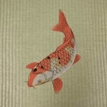 Embroidered tatami featuring crimson koi, displayed from spring through summer.