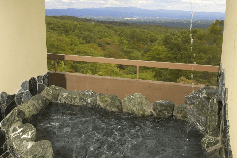 貸切風呂一例（岩露天）。関東平野一望の打たせ湯付き岩露天風呂。