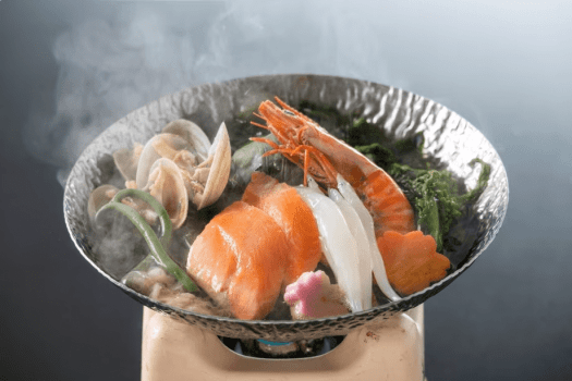 【鍋物】ふっくらとしたプラチナサツキマスや海の幸を春野菜と共に桜香る鰹出汁でほっこり味わう一品。