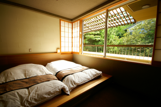 303号室：お布団のそばには大きな窓があり、いつでも自然を感じられます。