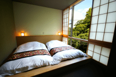 205号室：お布団のそばには大きな窓があり、いつでも自然を感じられます。