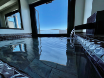 高層階客室の大きな浴槽の半露天風呂からは海一望！