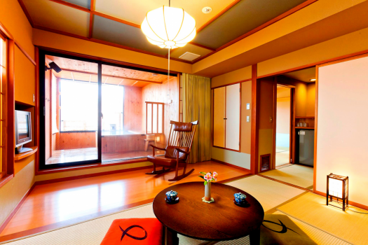 【千遊館・露天風呂付き客室（10畳+6畳）】居間川に面した部屋の大きな窓からは、湯田中温泉郷が一望できます。