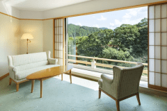 デラックスツイン：天井から床まで広がる大きな窓から左右に広がる渓流の景観はこの部屋ならでは。見下ろせば音信川の流れ、視線を遠くに移せば里山ののどかな景観が広がります。