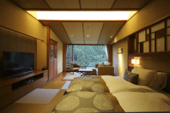 芙蓉 プレミアム：琉球畳の上にベッドを配置した和ツイン。和のやすらぎと、洋の快適さを兼ね備えたお部屋は、旅館ならではの時間をより心地よく演出いたします。窓枠がまるで額縁のように山々の緑が目に映ります。