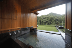 【露天風呂付・山側】曙 ジュニアスイート(約66㎡)：なだらかな山の稜線と大きく広がる空を眺めながら、源泉かけ流しの湯に浸かる時間。かつて、長州藩主も湯治に訪れた長門湯本の湯につかり、日常を離れたひとときをお過ごしくださいませ。