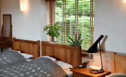 『洗心の間』のベッドルームの窓からは新緑をはじめ四季折々の自然の移ろいを感じることで寛いで頂けます。