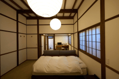 開放感のある高い天井と白い壁が印象的なお部屋。２台のベッドと大きなソファーをご用意。