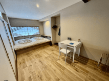 木目の柄が引き立つ白色を基調にベット式のお布団や旅日記を記載頂くイス・テーブルを用意しております。