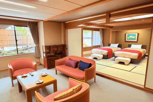 【仙渓園「芙蓉」温泉バス付和室】畳に置かれたベッドは大きな窓に面し、贅沢にお休みいただけます。