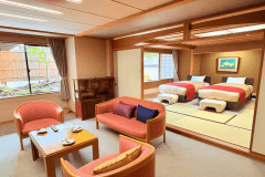 【仙渓園「芙蓉」温泉バス付和室】畳に置かれたベッドは大きな窓に面し、贅沢にお休みいただけます。