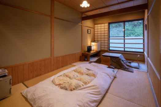 8畳ワンルームタイプ1名様定員。
2畳ほどのスペースにこたつがございます。テレビ、冷蔵庫、湯沸かしポットなど必要最小限の設備がございますので、ご滞在には過不足なくお過ごし頂けるかと存じます。