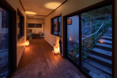 温泉館への渡り廊下。右手の出入口からは温泉神社へと続く。参拝も可能。下駄のご用意もございますが参道の石段が急ですので、ご自身の靴を持参して頂いたほうがよろしいかと存じます。参拝の際はスタッフにお声がけ下さいませ。