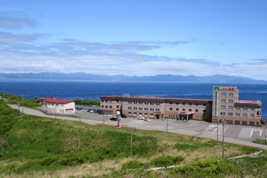 ホテル外観。背景に見える山並みは北海道です。