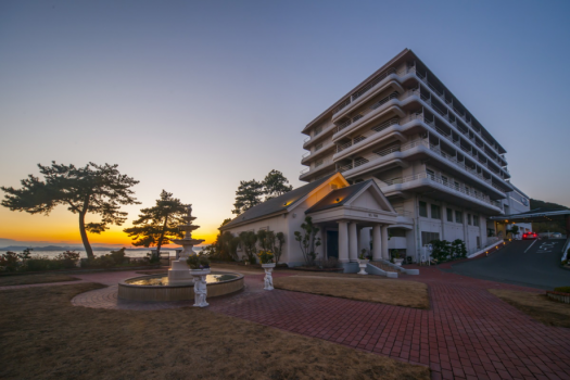 【ホテル外観（夕景）】ホテルの目の前には、一面に広がる瀬戸内海を望む事ができます。