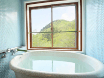 和モダン風客室の展望風呂。白い温泉を満喫しながら美しい景色も。レトロなタイルが可愛い♪